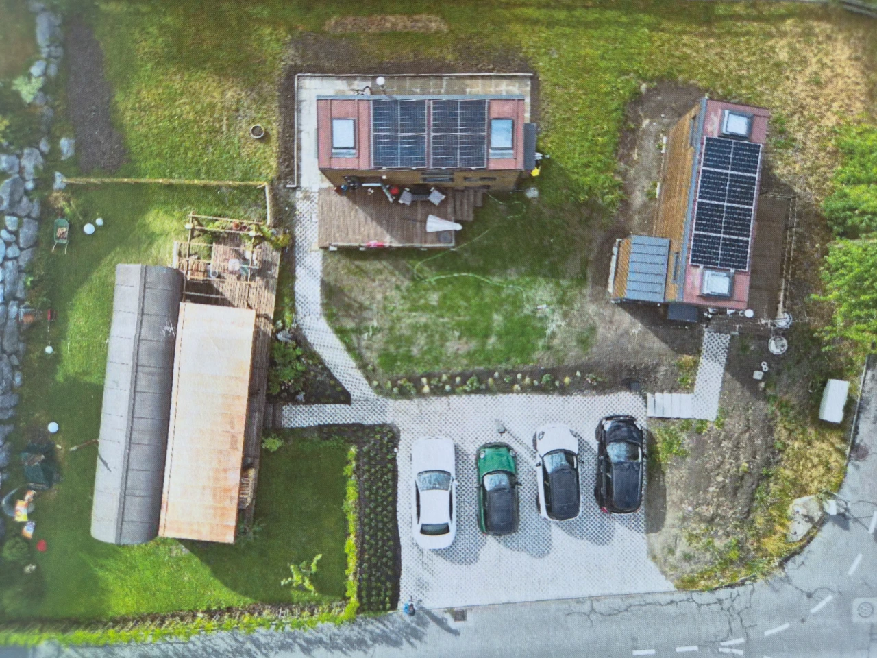 Projekt Maienfeld aus der Luft: zwei Tiny Houses mit Solarpanels, Parkplatz und Stall